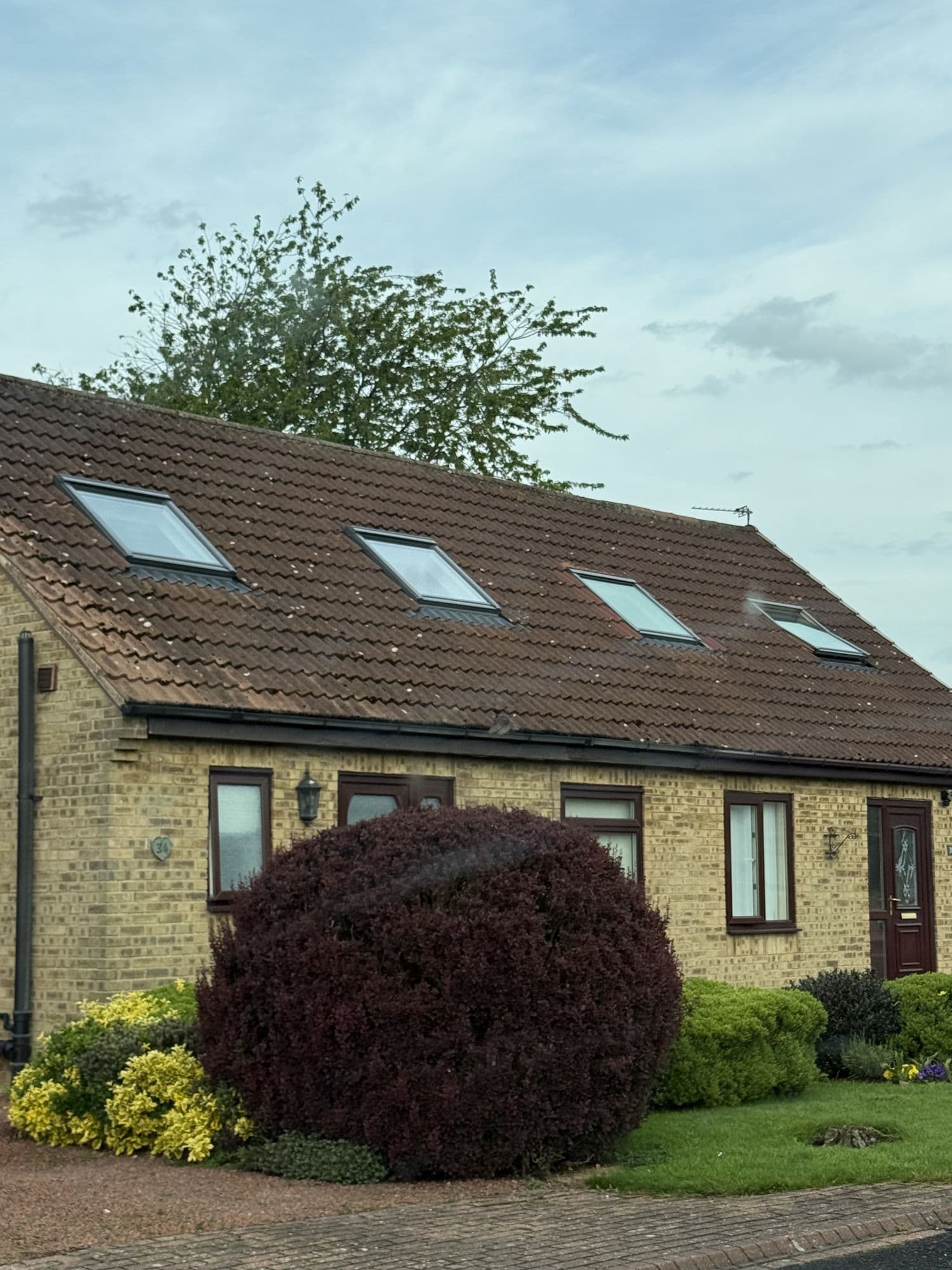 Brick-built house with three roof windows set into a tiled roof