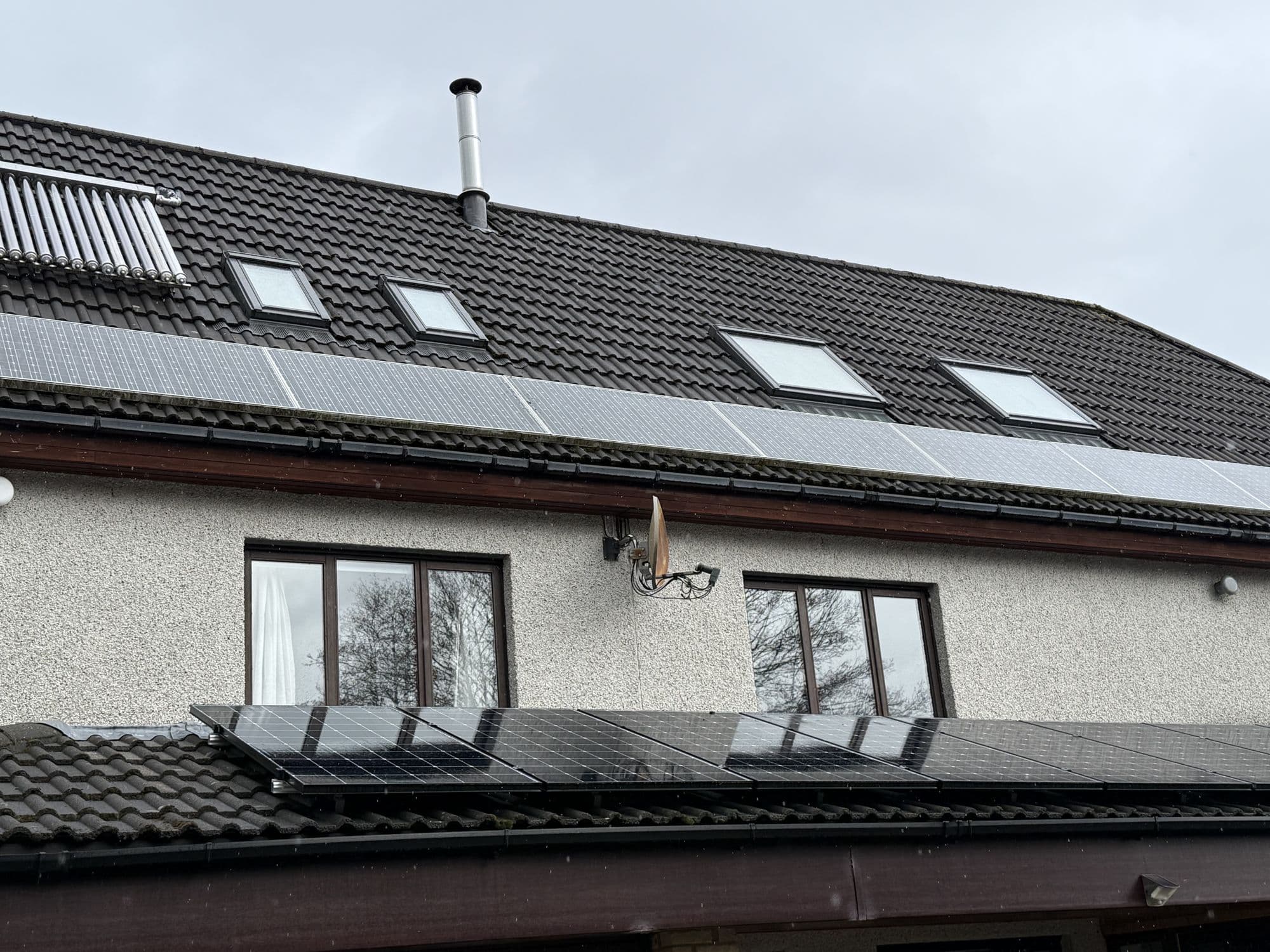 Rendered house with roof windows and solar panels on a dark roof